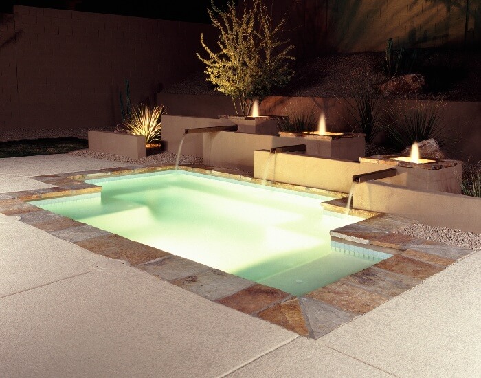Remodeled pool with fountains at night